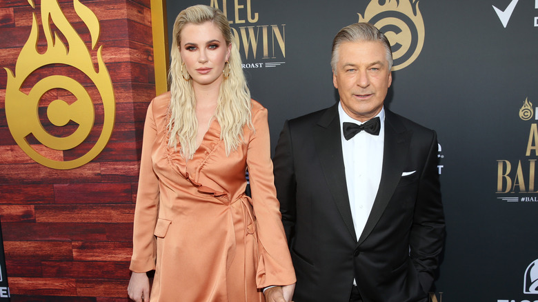 Ireland Baldwin and Alec Baldwin holding hands