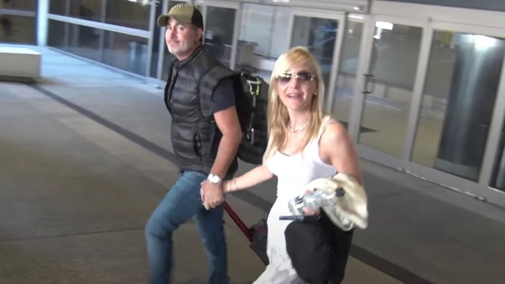Michael Barrett and Anna Faris holding hands at the airport 