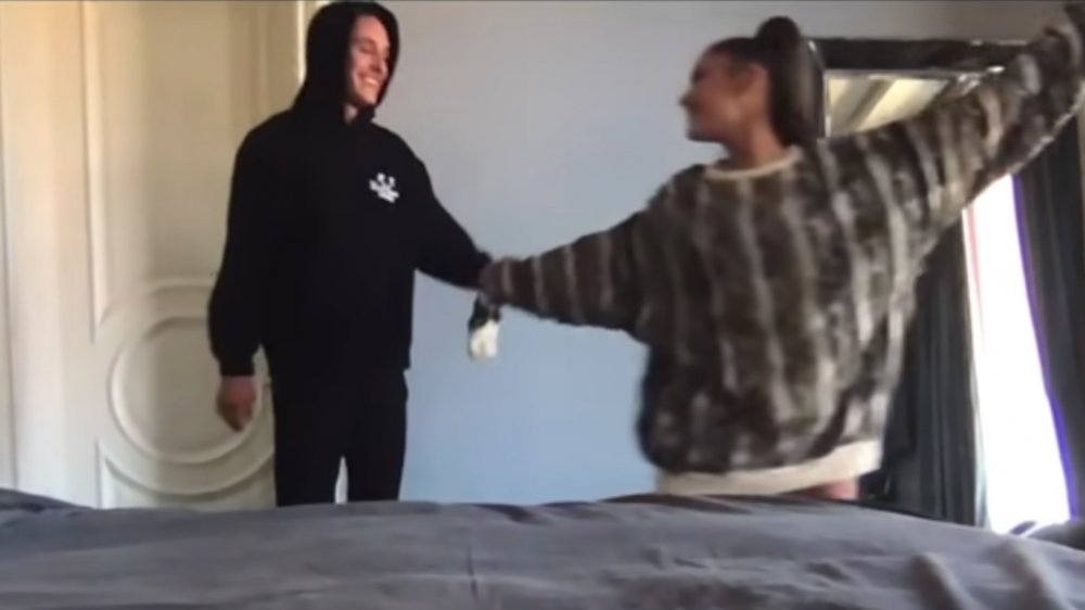 Dalton Gomez and Ariana Grande hand in hand standing in a bedroom