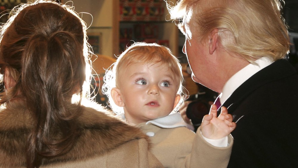 Melania Trump holding baby Barron Trump next to Donald Trump