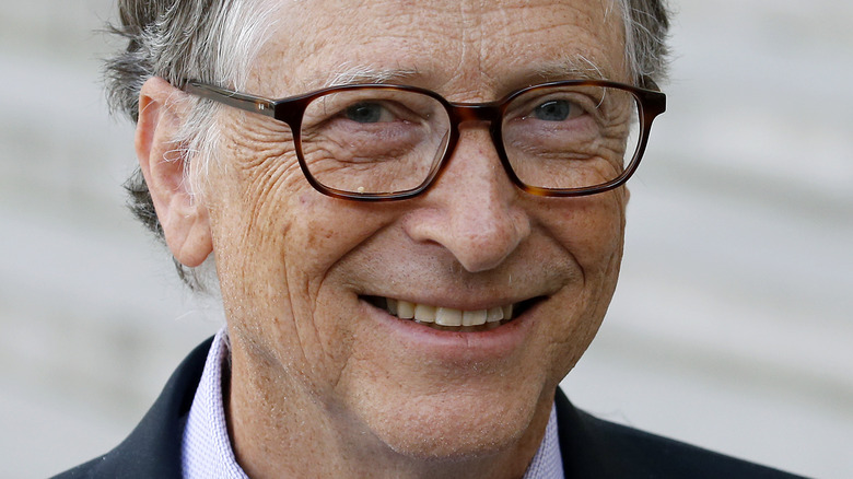 Bill Gates smiles in glasses.