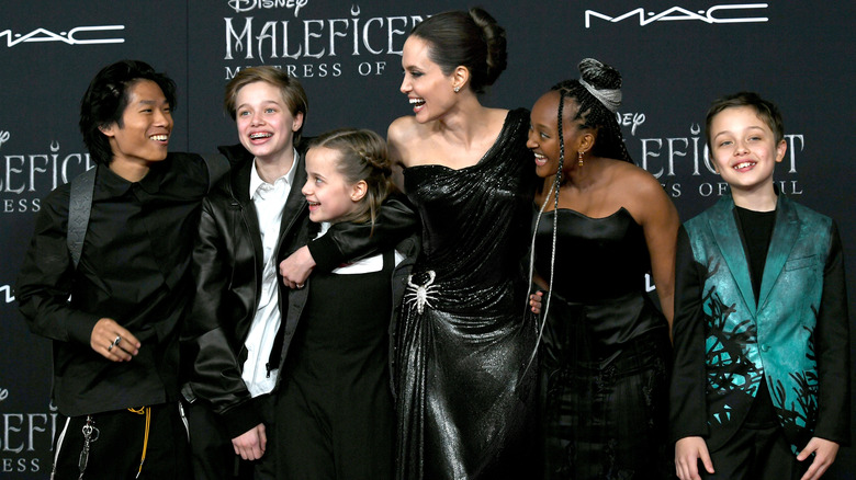 Pax Thien Jolie-Pitt, Shiloh Nouvel Jolie-Pitt, Vivienne Marcheline Jolie-Pitt, Angelina Jolie, Zahara Marley Jolie-Pitt and Knox Leon Jolie-Pitt smiling on a red carpet