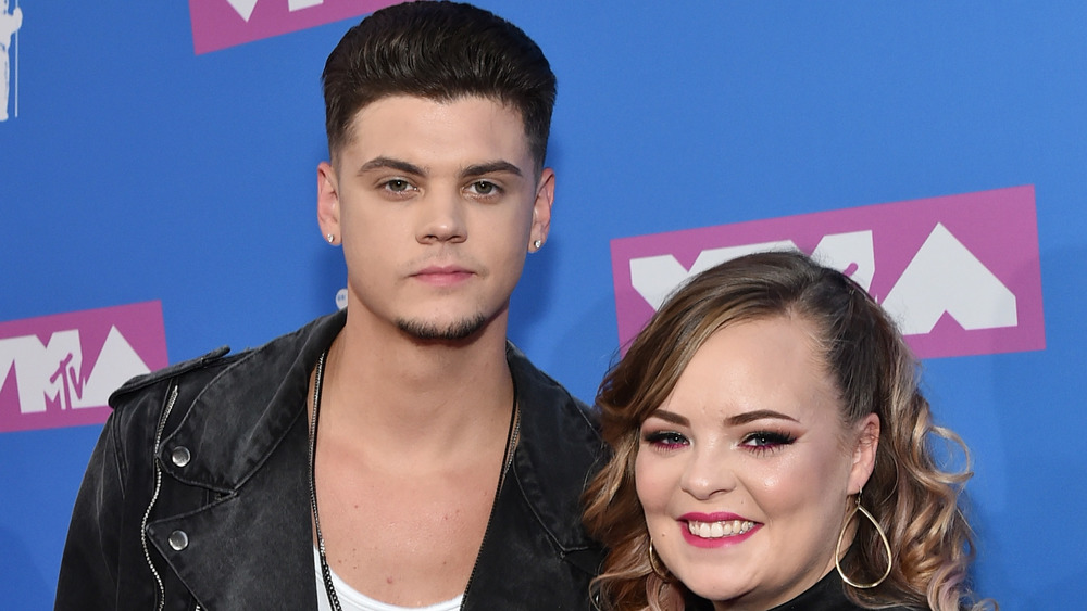 Tyler Baltierra, not smiling, red carpet, leather jacket; Catelynn Baltierra, smiling, curly hair, red carpet 