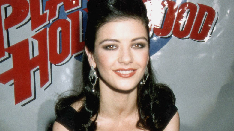 Catherine Zeta-Jones smiling in front of Planet Hollywood sign