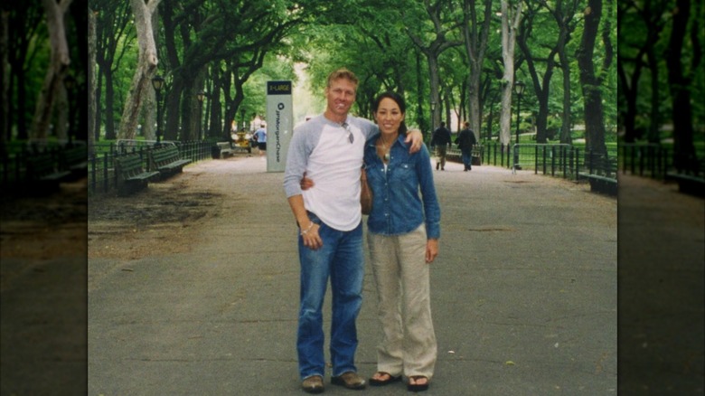 Chip Gaines and Joanna Gaines posing outdoors under trees