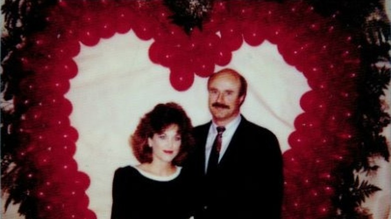 Robin McGraw and Dr. Phil McGraw posing in front of balloons