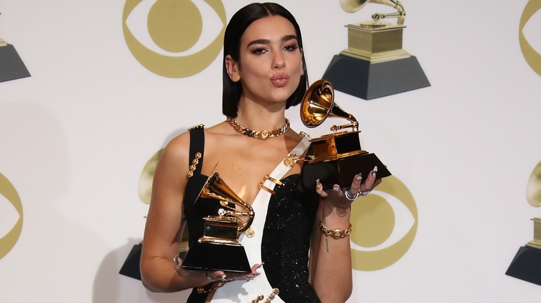 Dua Lipa posing with her Grammy Awards