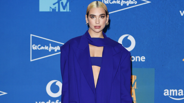 Dua Lipa on the red carpet, posing all in blue