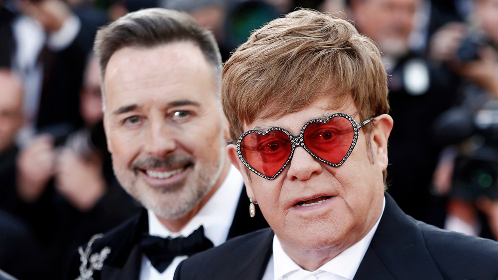 David Furnish smiling over Elton John's shoulder