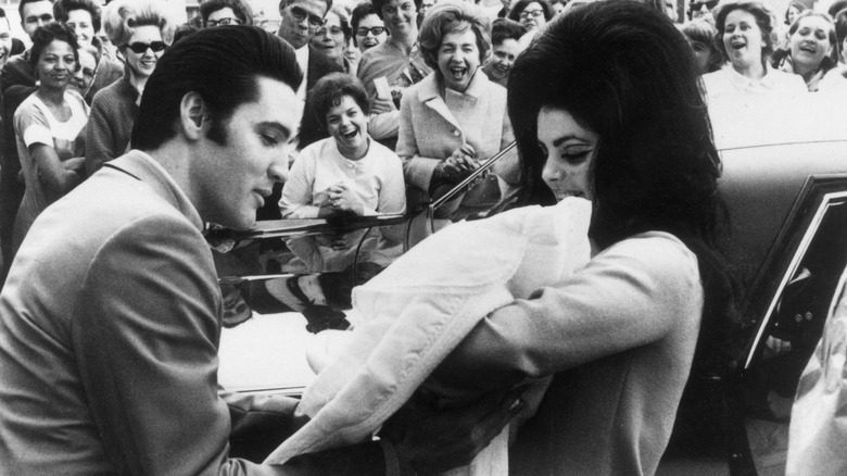 Priscilla and Elvis look at baby Lisa