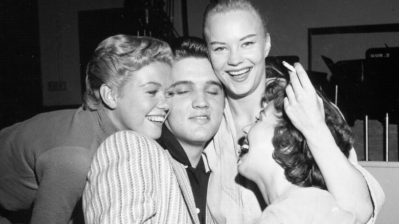 Elvis Presley cuddling with young women 