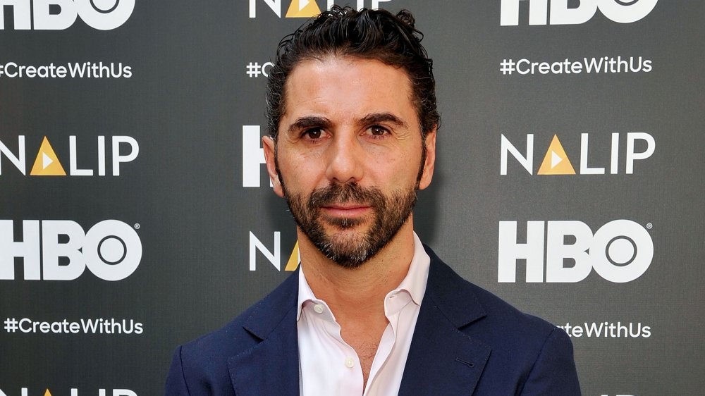 Jose Baston in front of HBO wall in a navy suit