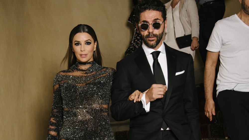 Eva Longoria in a black, sparkly dress and Jose Baston in a suit and sunglasses