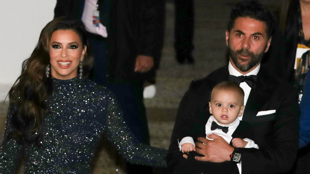 Eva Longoria smiling and Jose Baston carrying son Santiago Enrique Bastón