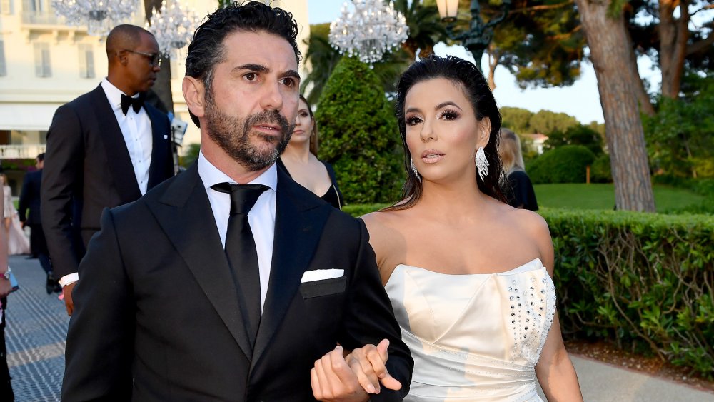 Jose Baston and Eva Longoria walking outside, dressed up