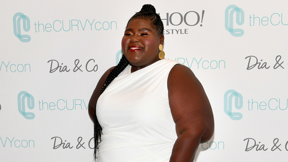 Gabourey Sidibe smiling in white dress