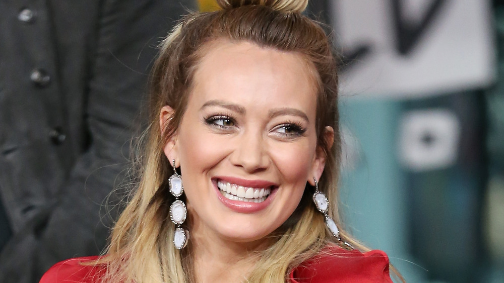 Hilary Duff smiling and wearing red