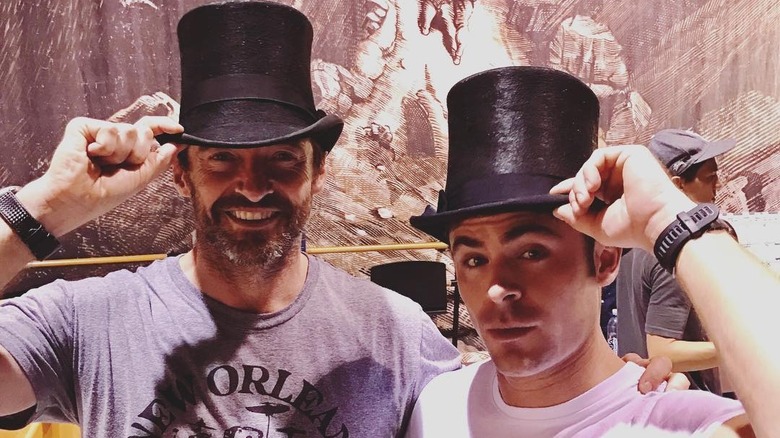 Hugh Jackman and Zac Efron posing