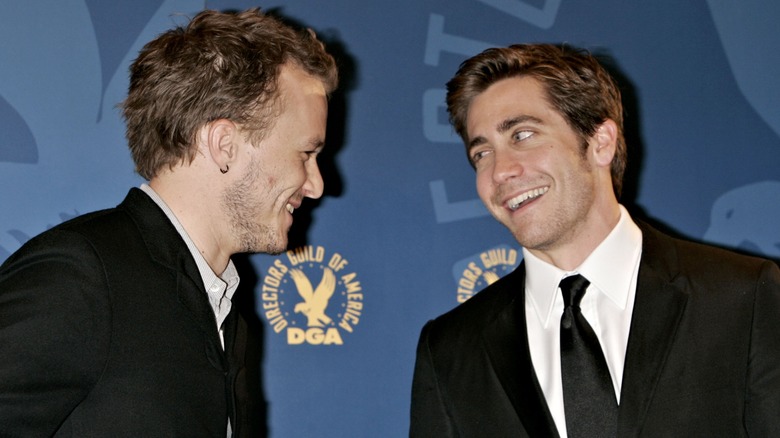 Jake Gyllenhaal and Heath Ledger smiling at each other