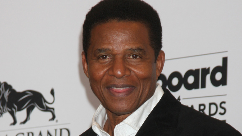 Jackie Jackson smiles in a black suit