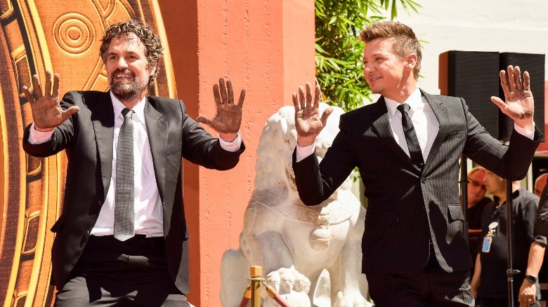 Mark Ruffalo and Jeremy Renner standing with hands raised
