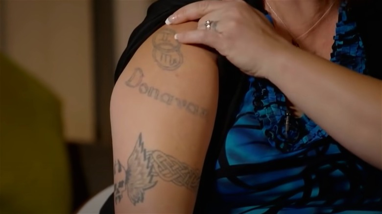 Tracy Brown showing her arm with tattoos