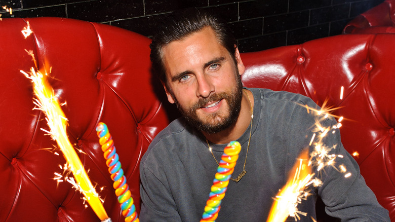 Scott Disick smiling with sparklers at birthday party 