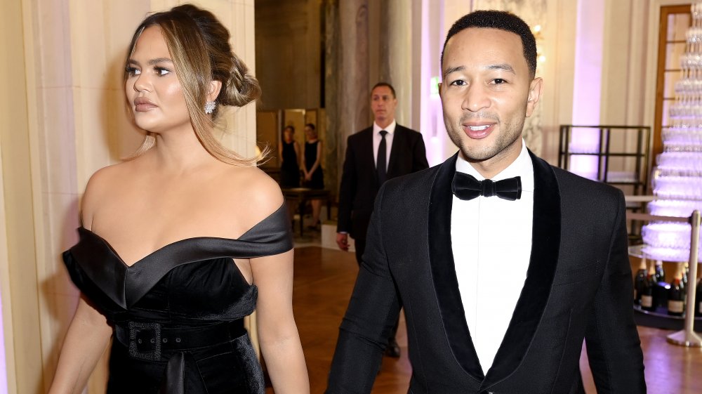 Chrissy Teigen and John Legend walking together at formal event