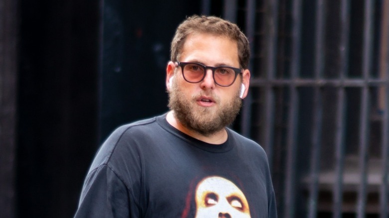 Jonah Hill wearing glasses and walking