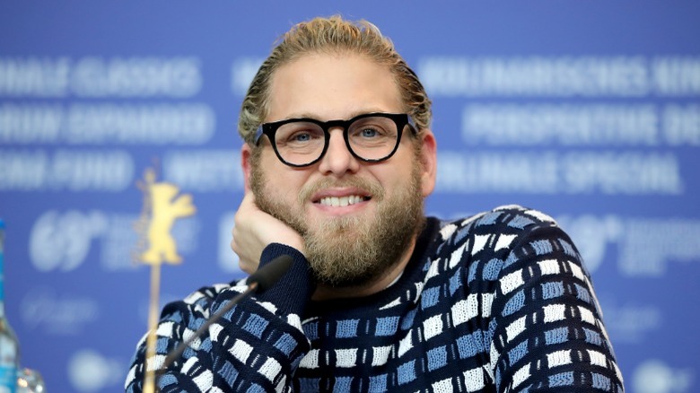 Jonah Hill smiling in blue sweater