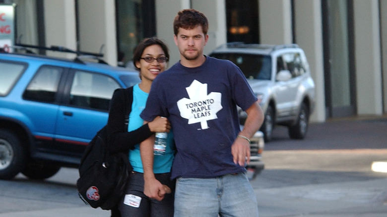 Rosario Dawson and Joshua Jackson smiling and walking on sidewalk together