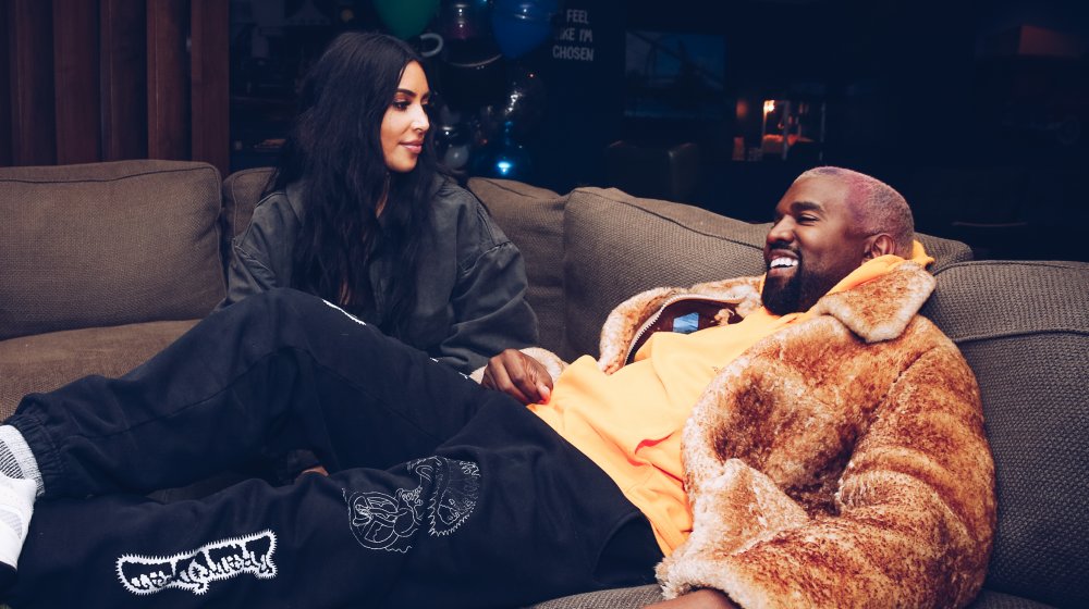 Kim Kardashian and Kanye West sitting on a couch