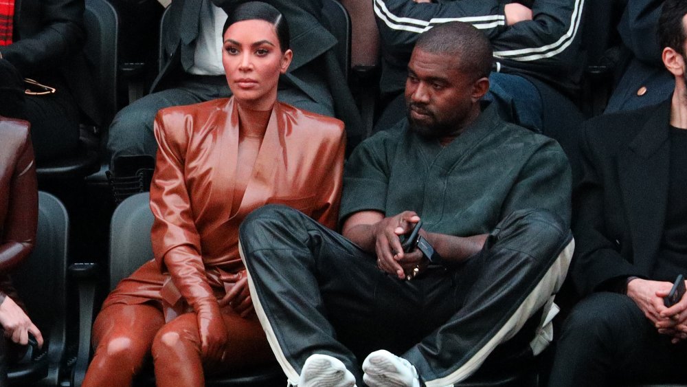 Kim Kardashian and Kanye West seated at a sporting event