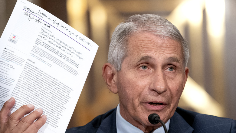 Dr. Anthony Fauci holding a report