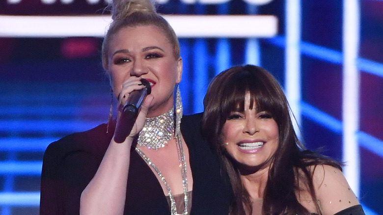 Kelly Clarkson and Paula Abdul embracing