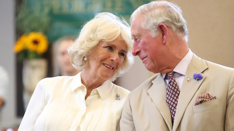 Queen Camilla and King Charles, both smiling at one another