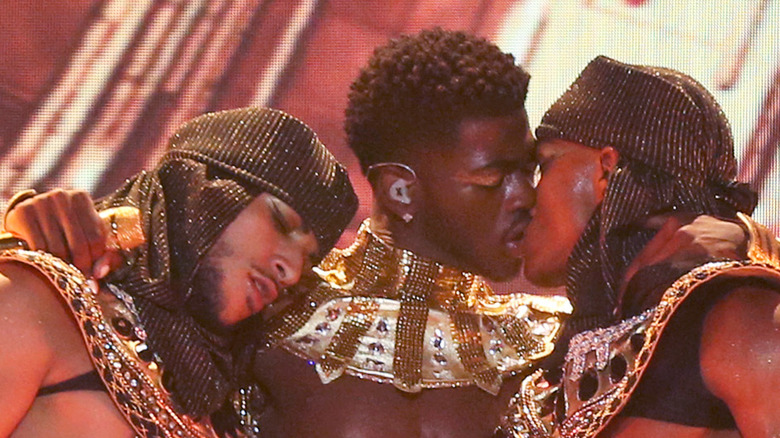 Lil Nas X locking lips with dancer on stage