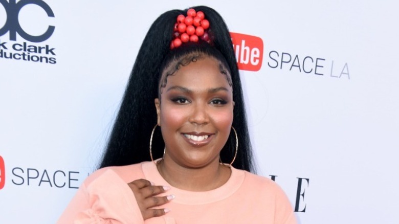 Lizzo smiles in a pink dress