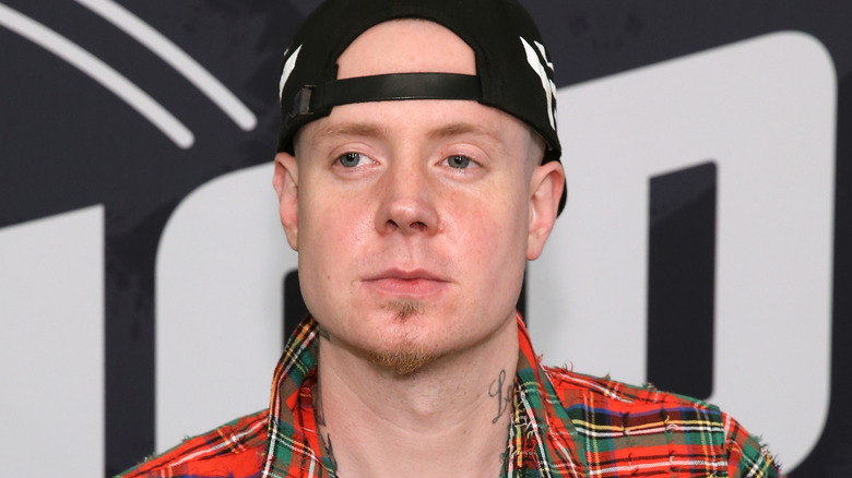 Millyz wearing a plaid, red shirt