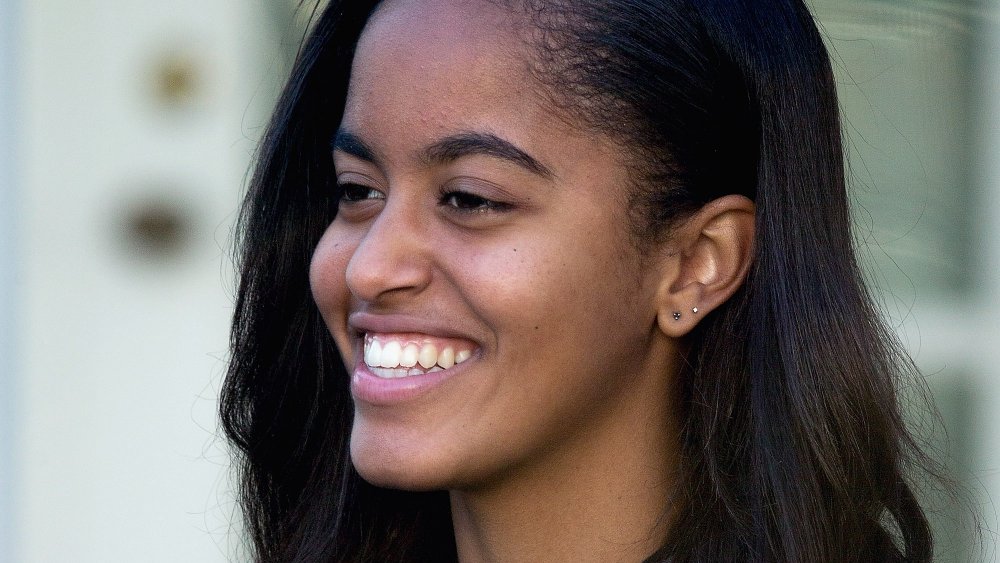 Malia Obama smiling while looking off to the side