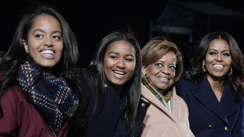 Sasha, Malia, and Michelle Obama smiling with Marian Robinson