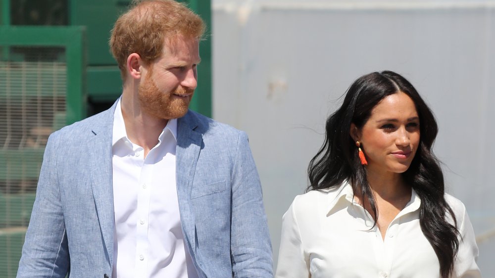 Prince Harry and Meghan Markle walking outside