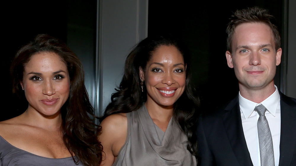 Meghan Markle, Gina Torres, and Patrick J. Adams smiling