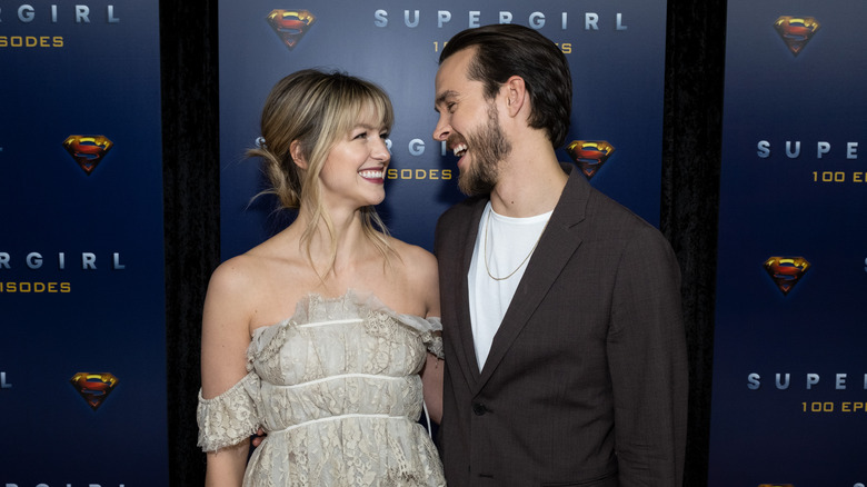 Melissa Benoist and Chris Wood smile at each other