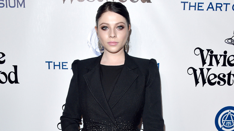 Michelle Trachtenberg wearing posing in a black outfit at an event