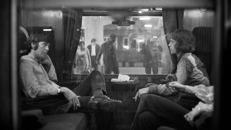 Paul McCartney and Mick Jagger together on a train.