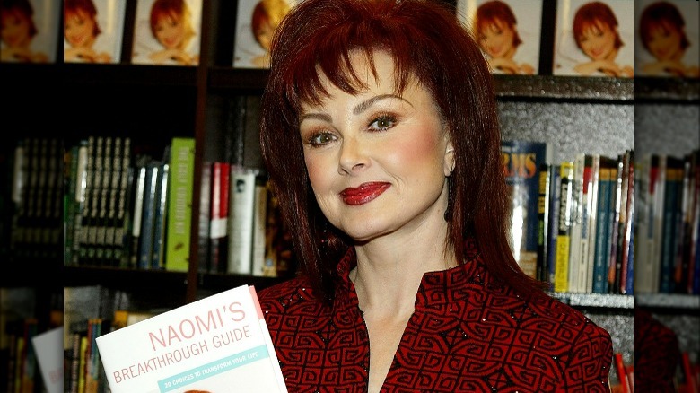 Naomi Judd posing with her book