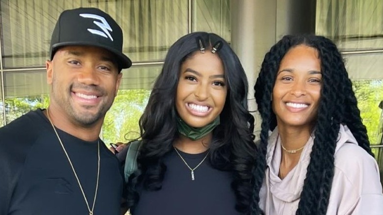 Russel Wilson posing with Natalia Bryant and Ciara