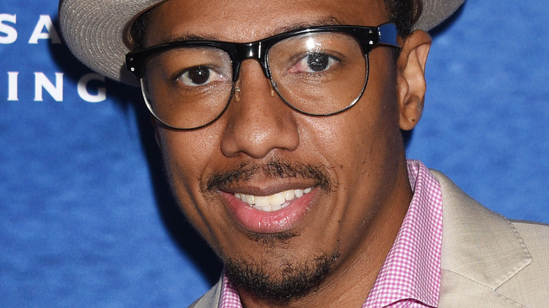 Nick Cannon wearing glasses and smiling