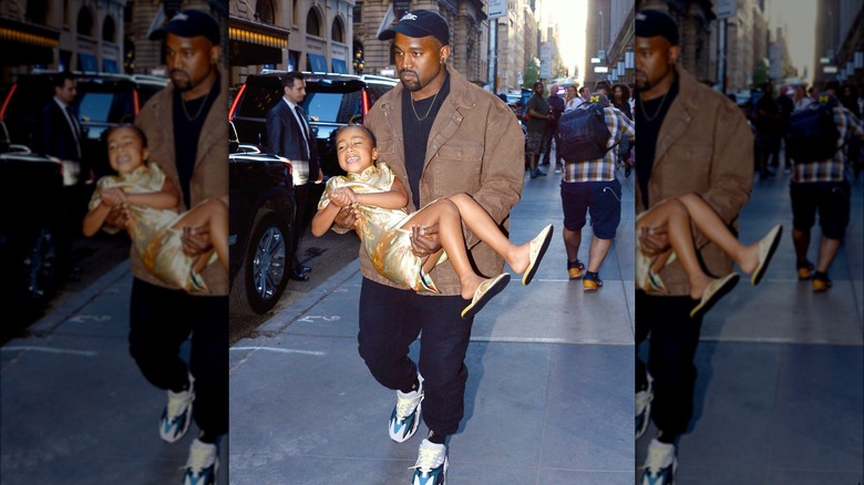 Kanye West carrying North West